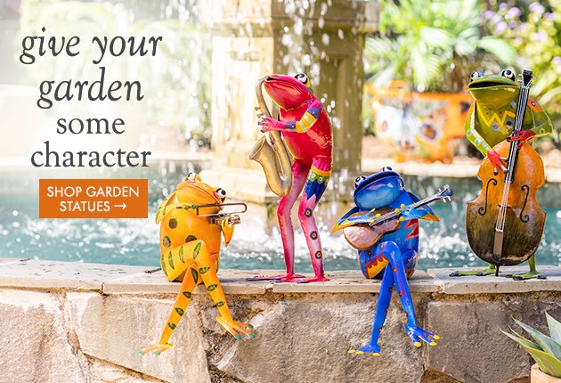Lifestyle Image of a band of 4 colorful metal frogs playing instruments, item GO8663. give your garden some character. SHOP GARDEN STATUES.
