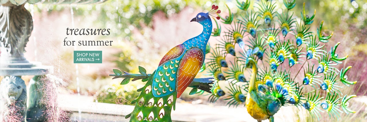 Lifestyle Image of a Peacock Garden Stake. treasures for summer. SHOP NEW ARRIVALS.
