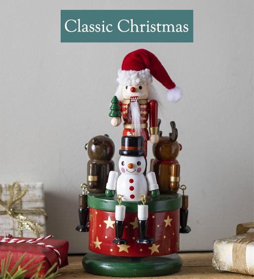 Image of a musical wooden Santa nutcracker toy. Shop Classic Christmas.