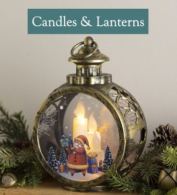 A charming lantern with a whimsical Santa painted on the front glows on a mantel
